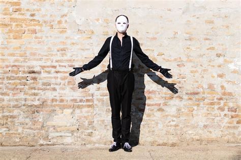 Premium Photo Man In Black Wearing White Mask While Standing Against