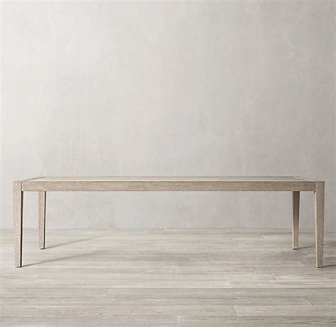 An Empty Table On A Wooden Floor In Front Of A White Wall