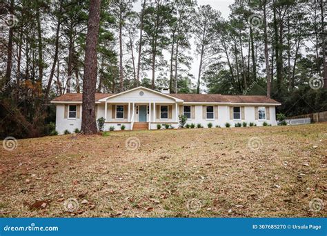 The Front Exterior Entrance of a Newly Painted White Siding Brick Ranch Style House with a Large ...