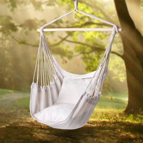 A White Hammock Chair Hanging From A Tree