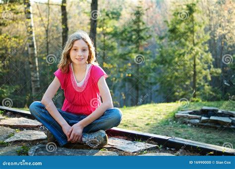 Menina Do Tween Que Senta Se De Pernas Cruzadas Foto De Stock Imagem