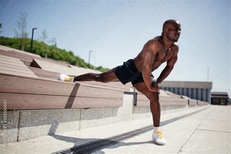 Darkskinned Athlete With A Naked Torso Does An Exercise To Stretch The Internal Muscles Of The
