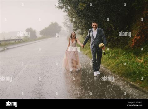 Just Married Couple Holding Hands And Walking On Rain Walking In Wet