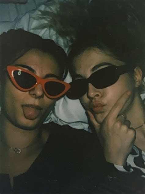 Two People Laying In Bed Wearing Sunglasses