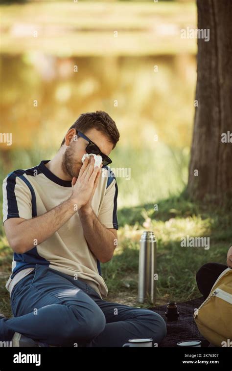 Boy Is Blowing His Nose While Sitting On A Picnic Stock Photo Alamy