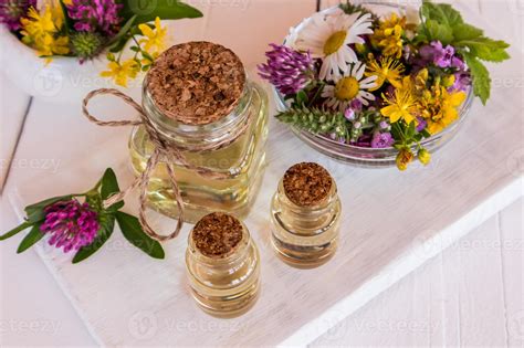 glass bottles with natural St. John's wort oil of white wooden boards