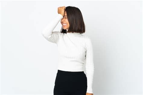 Mujer latina joven aislada en la pared blanca se ha dado cuenta de algo y tiene la intención de