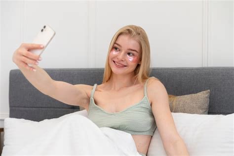 Mujer joven tomando un selfie mientras usa máscaras para los ojos