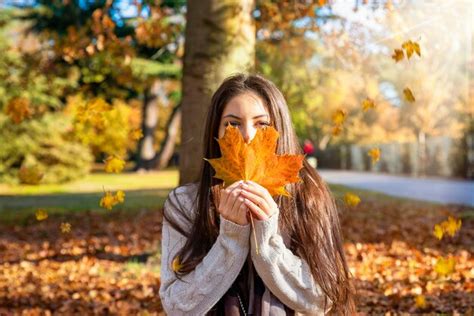 Premium Photo Portrait Of Young Woman Holding Autumn Leaves