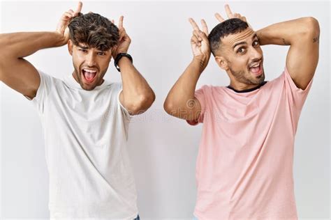 Jeune Couple Gay Debout Sur Fond Isol Posant Dr Le Et Fou Avec Des Doigts Sur La T Te Comme Des