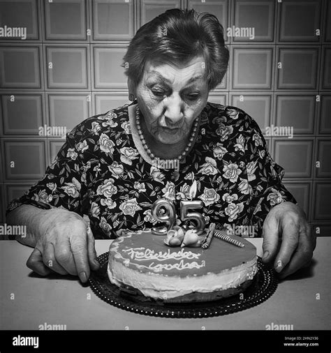 Old Woman Blowing Candles And Celebrating Her 95th Birthday In Black