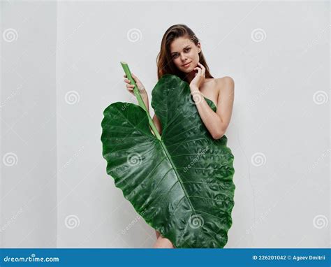 Attractive Red Haired Woman With Palm Leaf Covers Naked Body Stock