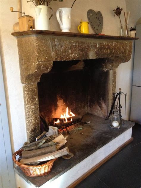 A Fireplace With Fire In It And Pots On The Mantle