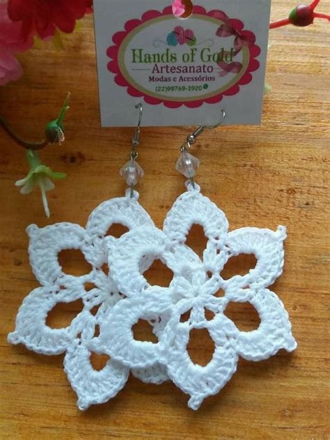 White Crochet Flower Earrings On Wooden Table Next To Business Card And