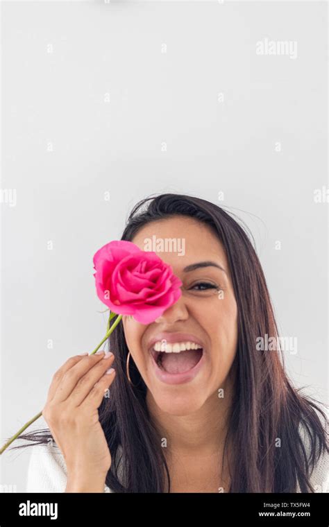 Cute Smiling Brunette Playing With A Red Rose Stock Photo Alamy
