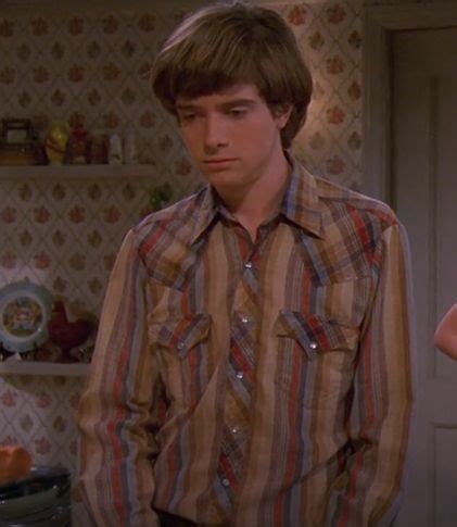 the young man is standing in his kitchen looking at the woman's hand on ...