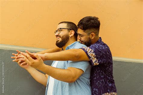Joven Gay Con Barba Abrazar Besa A Su Novio En La Espalda Mientras Le Sostiene Las Manos Stock