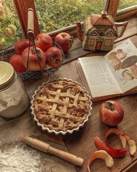 An Apple Pie Sitting On Top Of A Wooden Table Next To Apples And Other