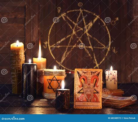 La Carta De Tarot Del Diablo Con Las Velas Y Pentagram Foto De Archivo