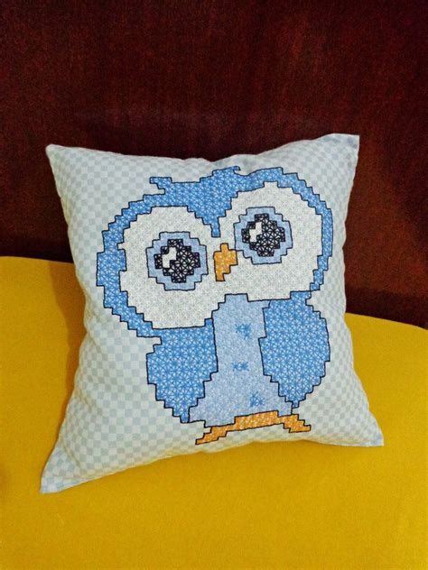 A Blue And White Owl Pillow Sitting On Top Of A Yellow Chair