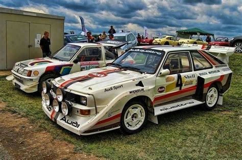 Two Race Cars Parked Next To Each Other On The Grass