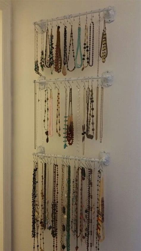 A Wall Mounted Jewelry Rack Filled With Lots Of Necklaces