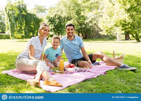 Familia Feliz Que Tiene Comida Campestre En El Parque Del Verano Imagen