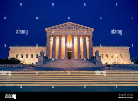 United States Supreme Courts building illuminated at night in Washington DC with steps and plaza ...