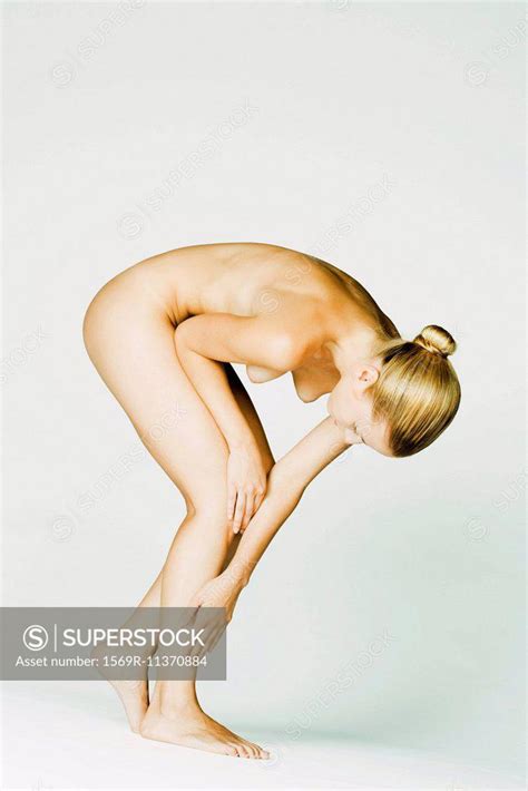 Nude Woman Bending Over Touching Shin SuperStock