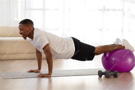 Premium Photo | Athletic black guy doing workout at home using fitness ball