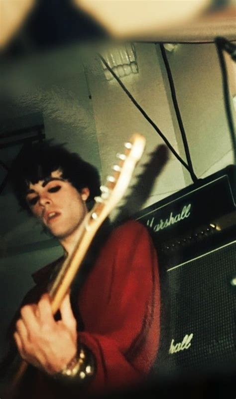 A Man Playing An Electric Guitar In Front Of A Speaker