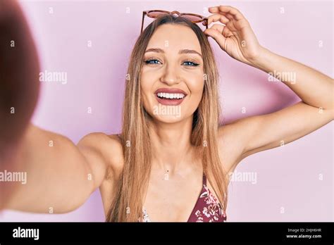 Junges blondes Mädchen trägt Bikini ein Selfie lächelnd und lacht laut weil lustig verrückt