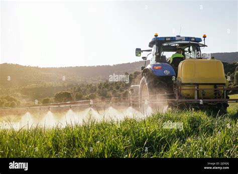 El joven agricultor pulveriza fertilizante a través de la pulverizadora