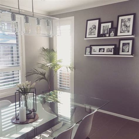 A Dining Room Table With Chairs And Pictures On The Wall Above It In