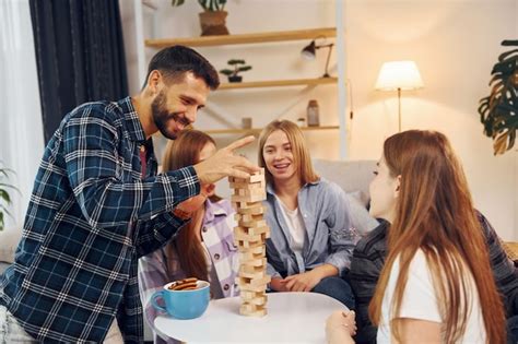 Premium Photo Wooden Tower Game On The Table Group Of Friends Have Party Indoors Together