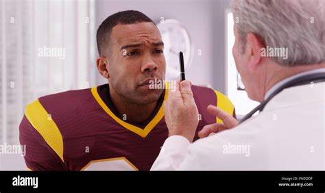 Portrait Of Handsome Football Player Consulting Sports Injury With A