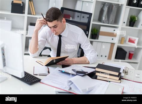 Un Jeune Homme Qui Travaille Une Table Dans Le Bureau Avec Un Livre