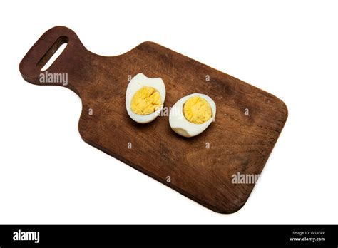 Boiled Egg Split In Two Halves On A Wooden Board All On A White