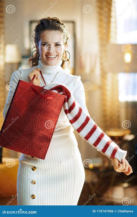 Smiling Woman With Red Shopping Bag Showing Purchased Sweater Stock