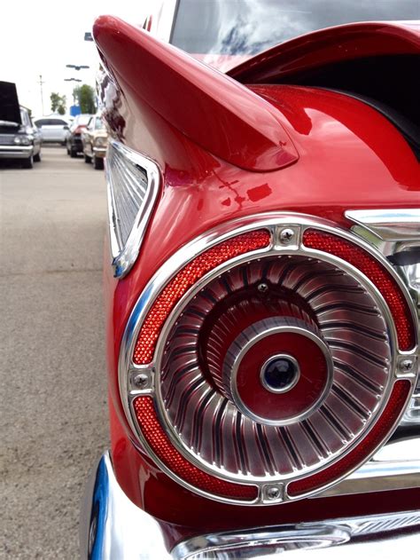 The Front End Of A Red Car With Chrome Rims And An Air Vent On It