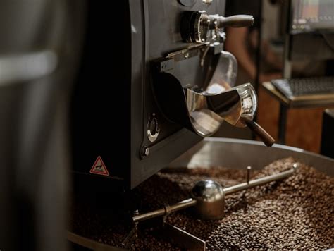 Máquina tostadora de café con granos de café en bandeja de enfriamiento