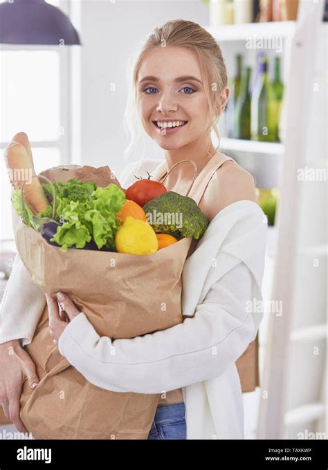 Young Woman Holding Grocery Shopping Bag With Vegetables Standi Stock