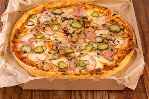 Round Pizza With Different Ham Mushrooms And Pickled Cucumbers Served