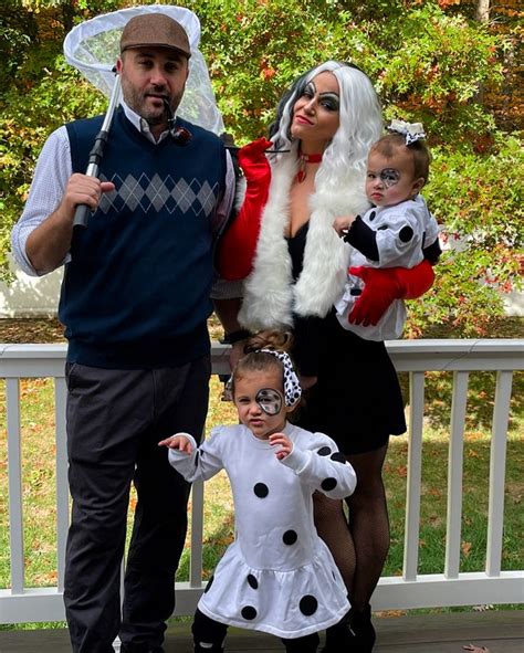 a family dressed up for halloween standing on a porch with one child in ...