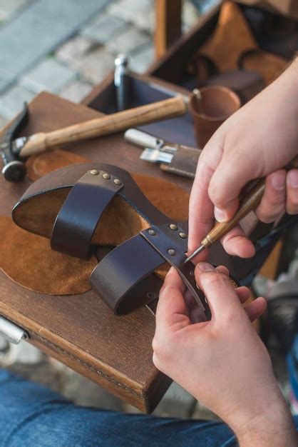 Premium Photo Close Up Of Shoemaker Making Sandal At Workshop