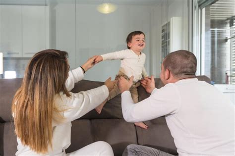 Vista Trasera De Una Familia Feliz Jugando Y Levantando Un Beb En El