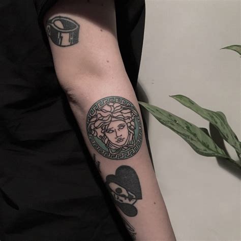 Versace logo tattoo by artist berkin dönmez - Tattoogrid.net