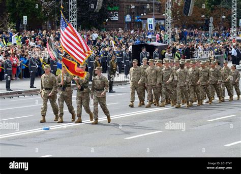 US military men, officers flying flag of USA, marching on a square ...