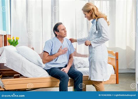 Middle Aged Man With Chest Pain And Doctor Standing Near Him Stock