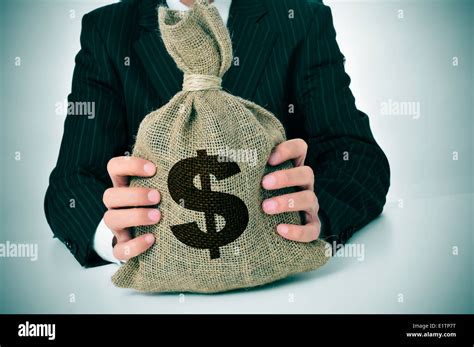 A Man Wearing A Black Suit Holding A Burlap Money Bag Stock Photo Alamy